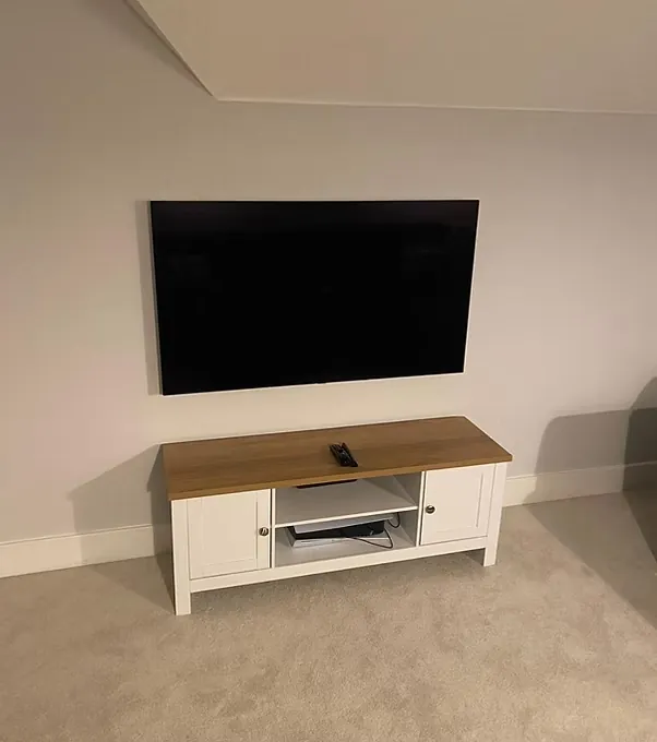 Wall-mounted television above a white media unit